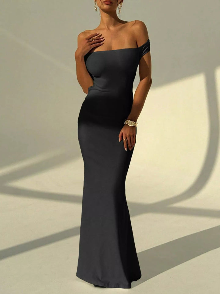 Backless Off-Shoulder Mermaid Dress featuring open back detail, fitted bodycon silhouette, elegant off-shoulder neckline, and floor-length flared hem.