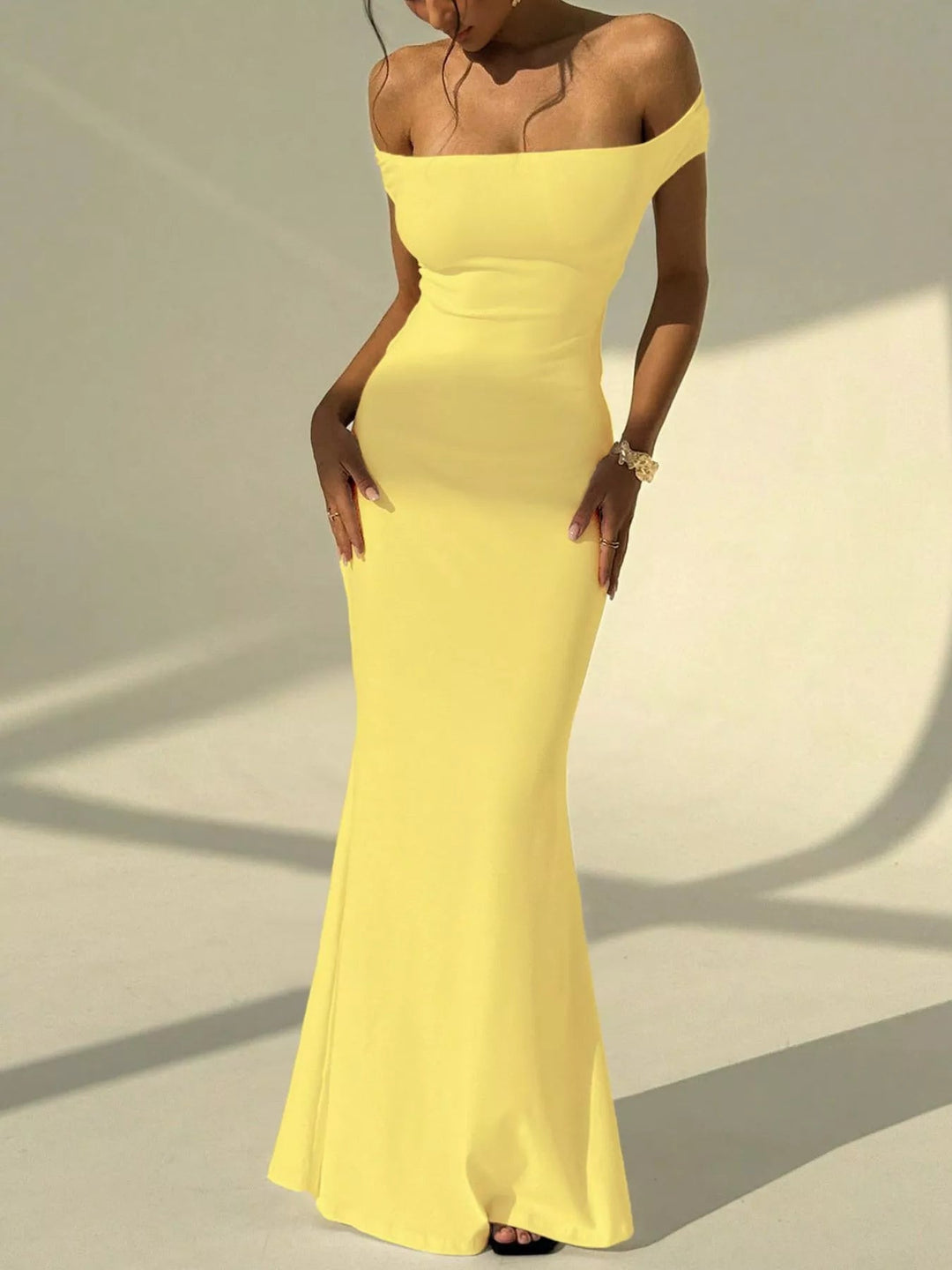 Backless Off-Shoulder Mermaid Dress featuring open back detail, fitted bodycon silhouette, elegant off-shoulder neckline, and floor-length flared hem.