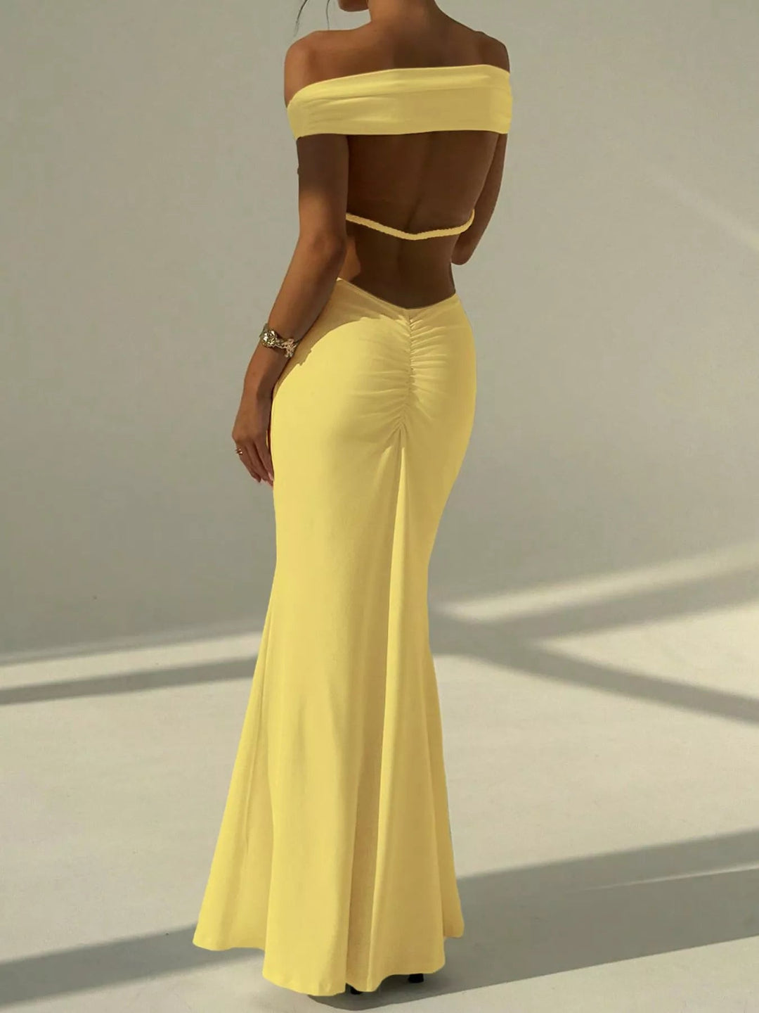 Backless Off-Shoulder Mermaid Dress featuring open back detail, fitted bodycon silhouette, elegant off-shoulder neckline, and floor-length flared hem.