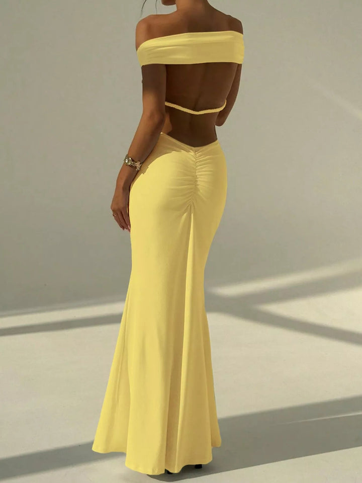 Backless Off-Shoulder Mermaid Dress featuring open back detail, fitted bodycon silhouette, elegant off-shoulder neckline, and floor-length flared hem.