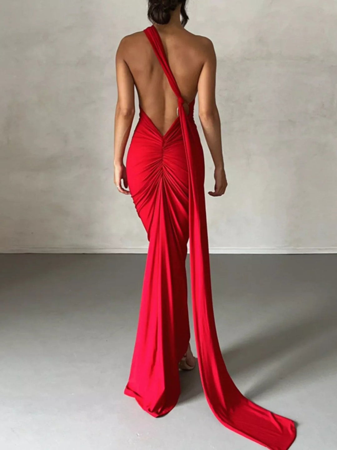 Backless One-Shoulder Bodycon Dress with ruched detailing, asymmetrical neckline, open back design, and elegant floor-length fitted silhouette.