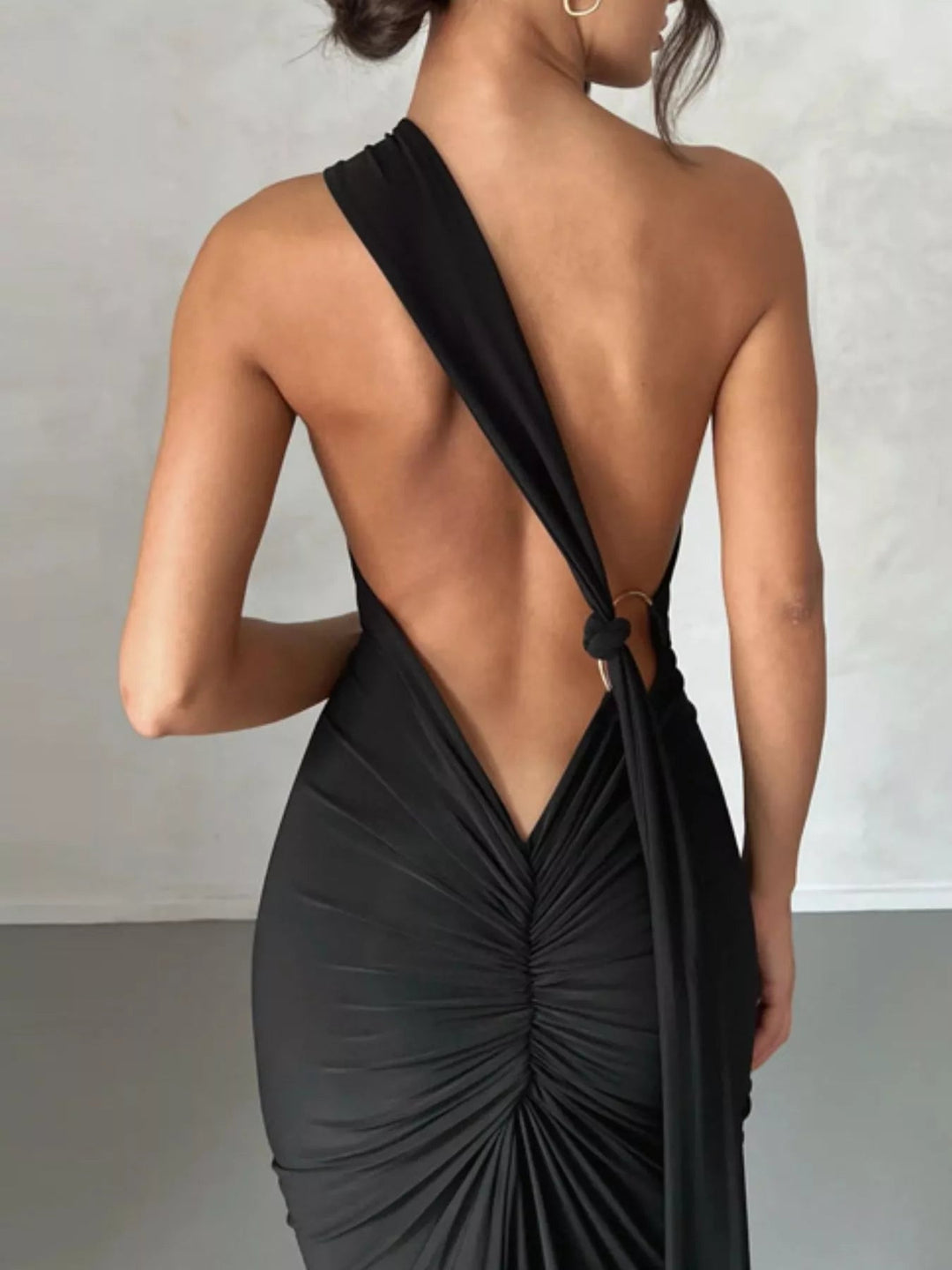 Backless One-Shoulder Bodycon Dress with ruched detailing, asymmetrical neckline, open back design, and elegant floor-length fitted silhouette.