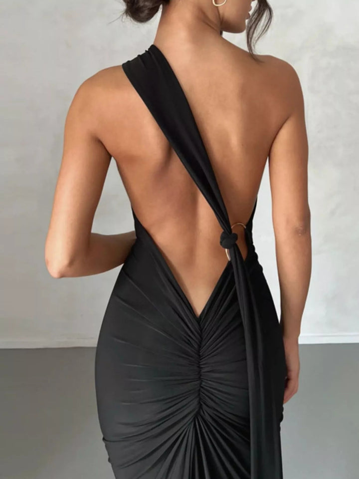Backless One-Shoulder Bodycon Dress with ruched detailing, asymmetrical neckline, open back design, and elegant floor-length fitted silhouette.