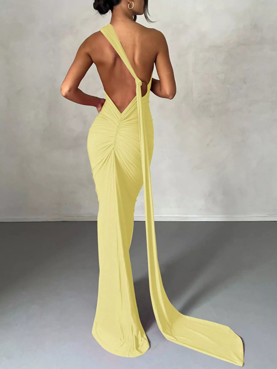 Backless One-Shoulder Bodycon Dress with ruched detailing, asymmetrical neckline, open back design, and elegant floor-length fitted silhouette.