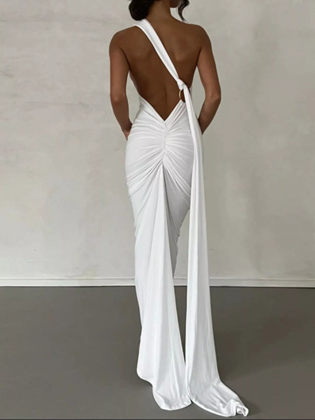Backless One-Shoulder Bodycon Dress with ruched detailing, asymmetrical neckline, open back design, and elegant floor-length fitted silhouette.