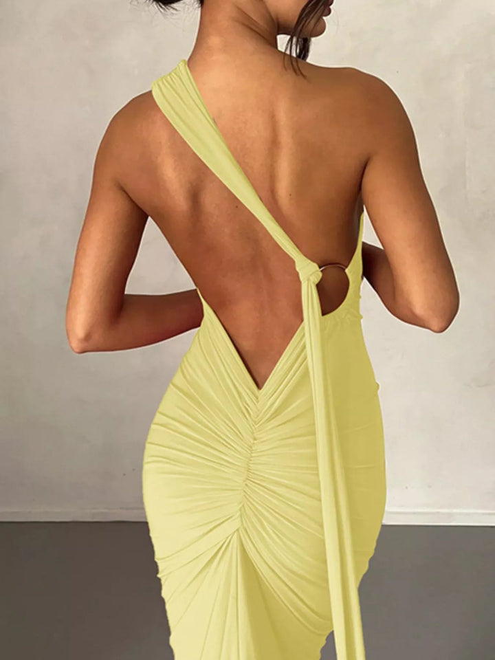 Backless One-Shoulder Bodycon Dress with ruched detailing, asymmetrical neckline, open back design, and elegant floor-length fitted silhouette.