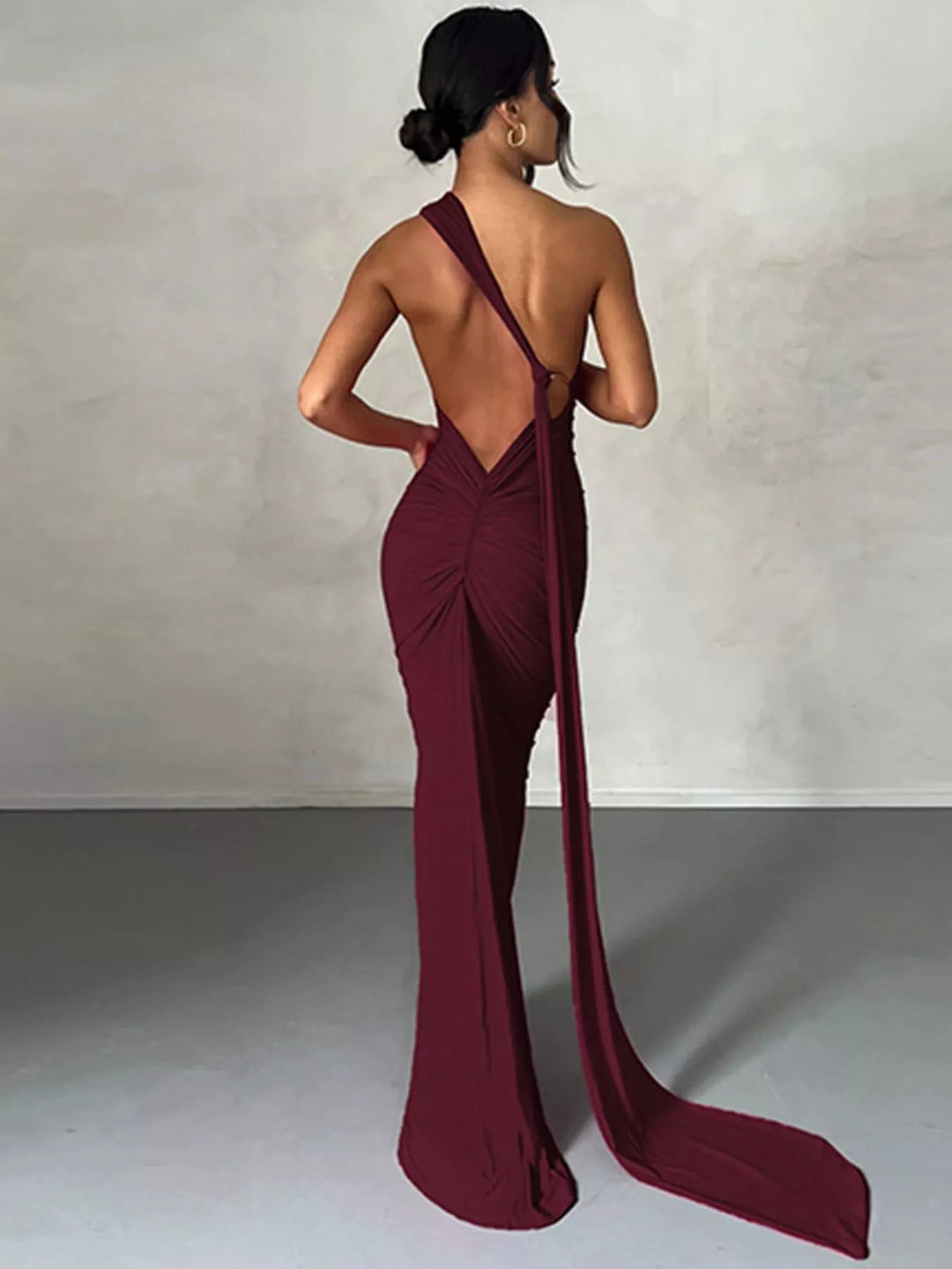 Backless One-Shoulder Bodycon Dress with ruched detailing, asymmetrical neckline, open back design, and elegant floor-length fitted silhouette.