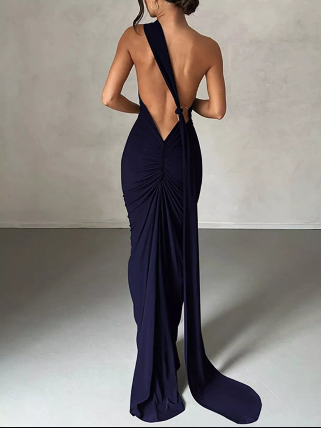 Backless One-Shoulder Bodycon Dress with ruched detailing, asymmetrical neckline, open back design, and elegant floor-length fitted silhouette.