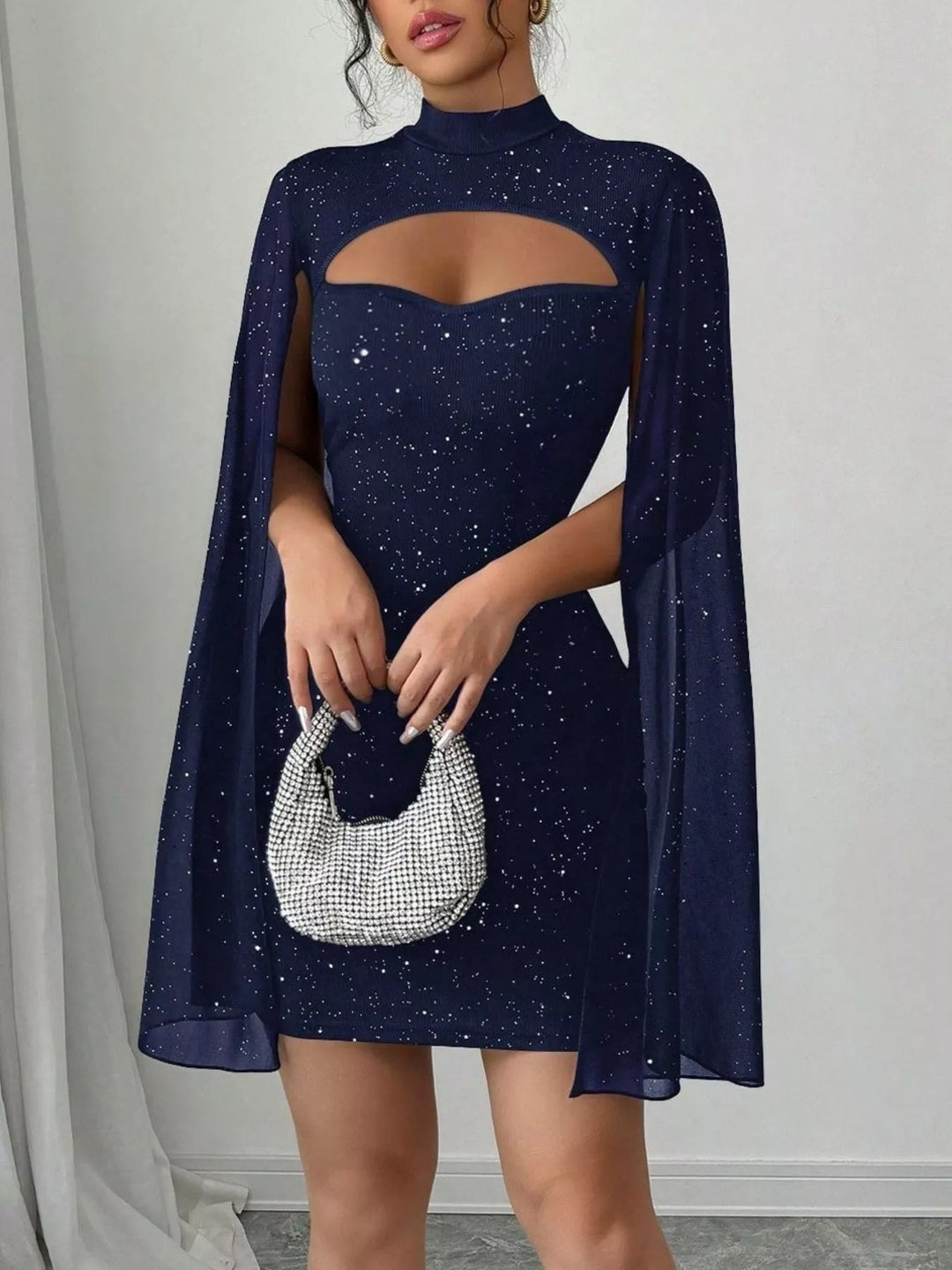 Glitter Cape Sleeve Mini Dress featuring shimmering fabric, elegant cape sleeves, subtle front cutout detail, and fitted bodycon mini silhouette.