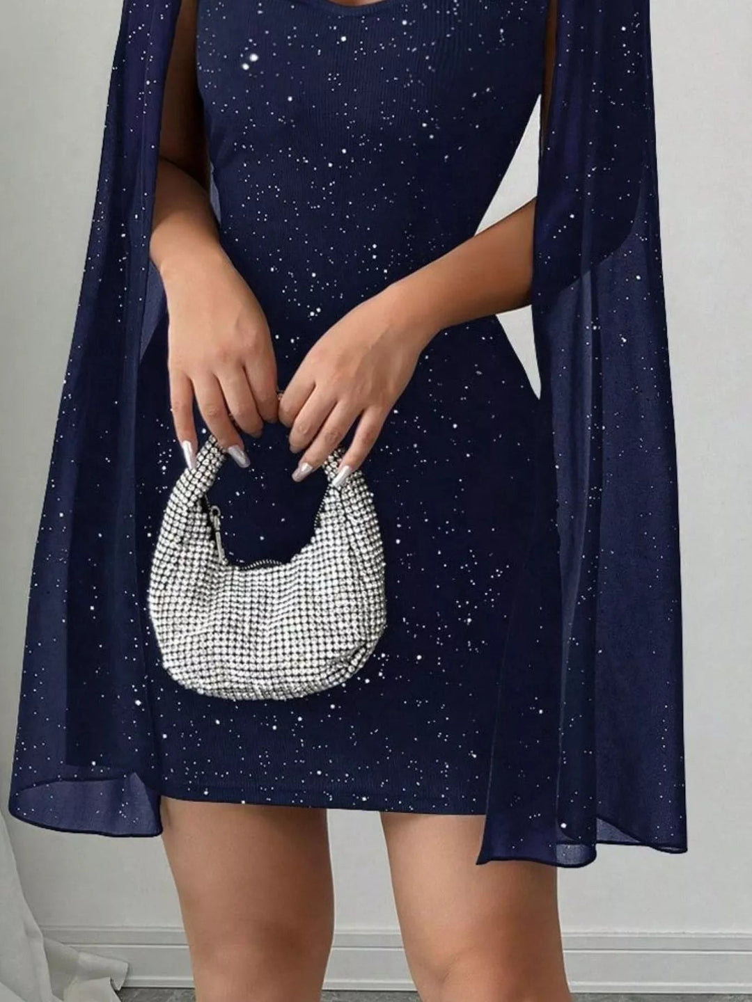 Glitter Cape Sleeve Mini Dress featuring shimmering fabric, elegant cape sleeves, subtle front cutout detail, and fitted bodycon mini silhouette.