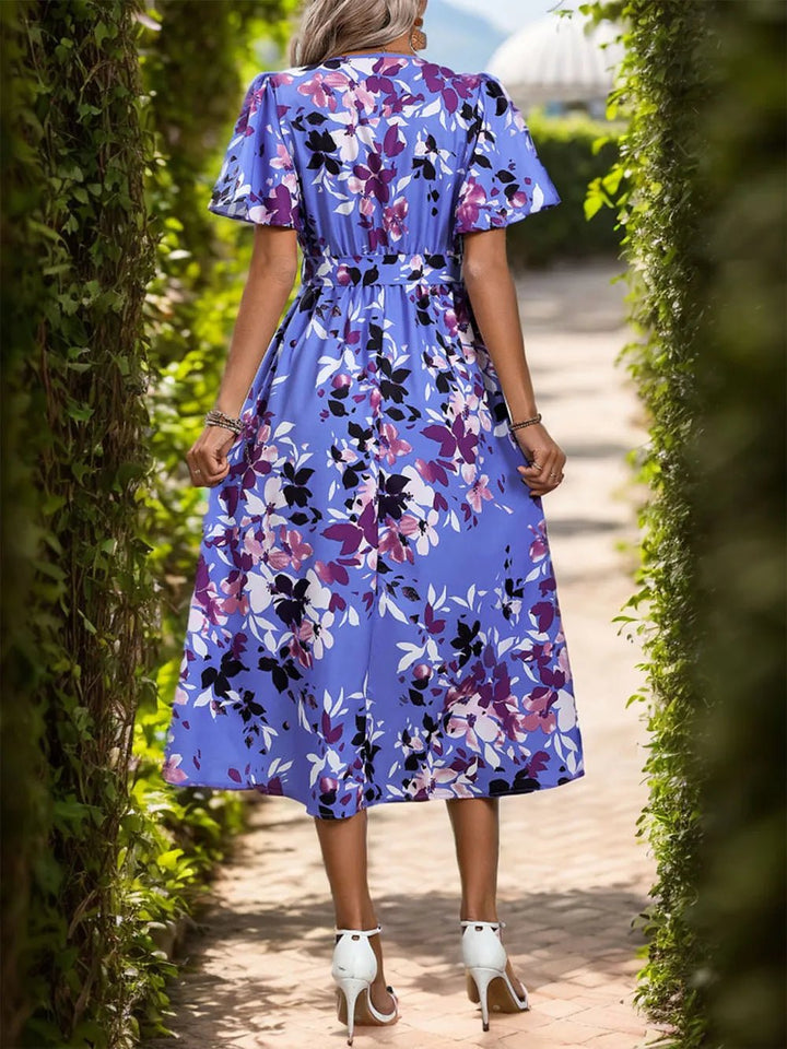 High-Low Printed Midi Dress with surplice neckline, tie waist detail, short sleeves, and flowing asymmetrical hemline.