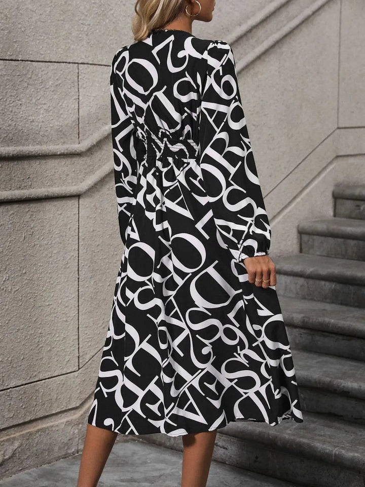 Printed V-Neck Midi Dress with long sleeves, buttoned front detail, and flowing midi-length silhouette in opaque fabric.