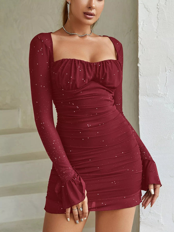 Ruched Glitter Bodycon Dress with sheer mesh panels, sparkling glitter fabric, fitted mini silhouette, and zip-back closure detail.