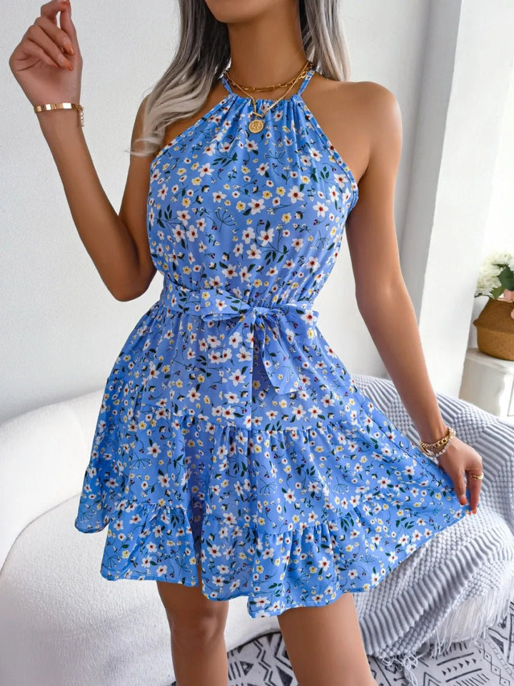 Printed Grecian Mini Dress with tied neckline, bold allover print, sleeveless silhouette, and mini-length hemline.
