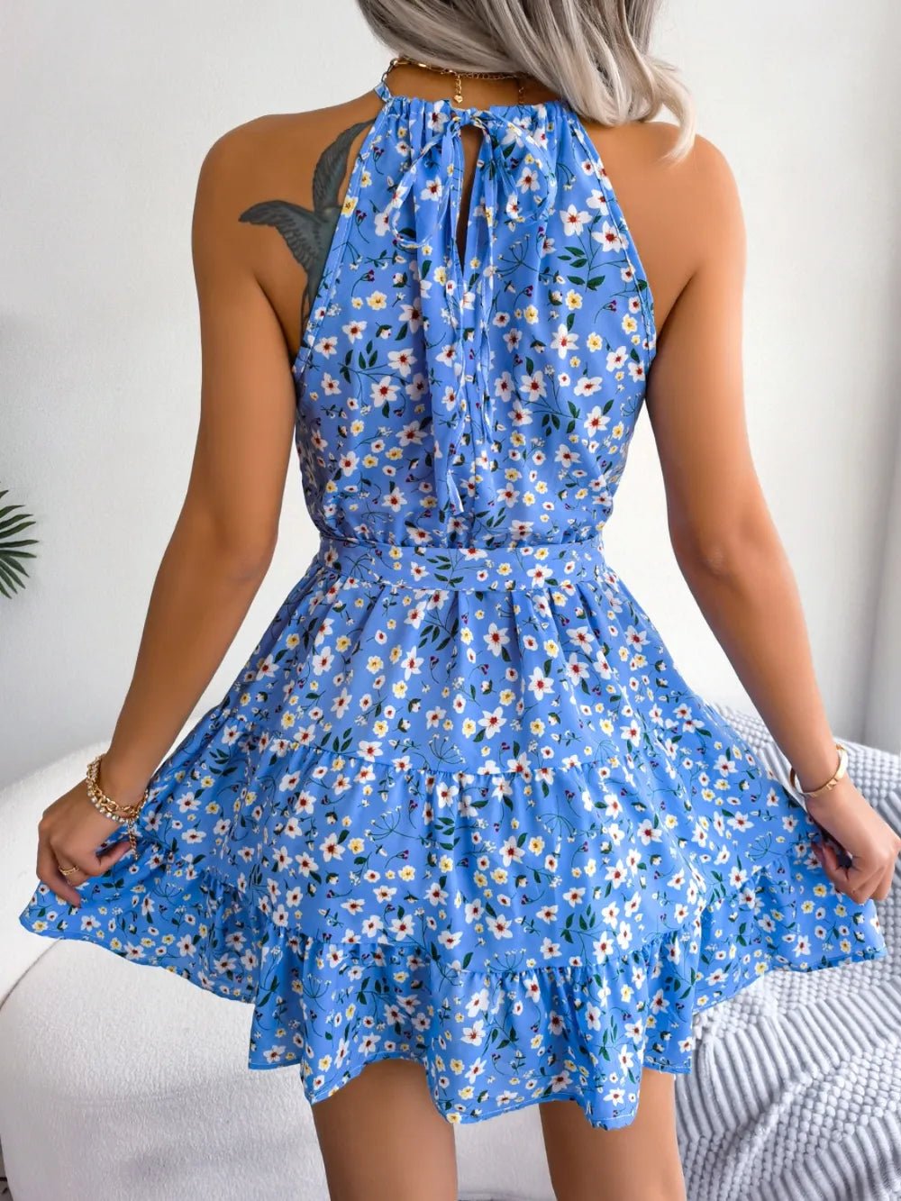 Printed Grecian Mini Dress with tied neckline, bold allover print, sleeveless silhouette, and mini-length hemline.