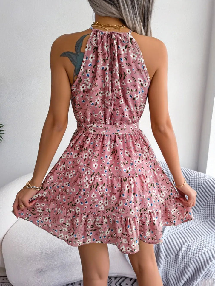 Printed Grecian Mini Dress with tied neckline, bold allover print, sleeveless silhouette, and mini-length hemline.