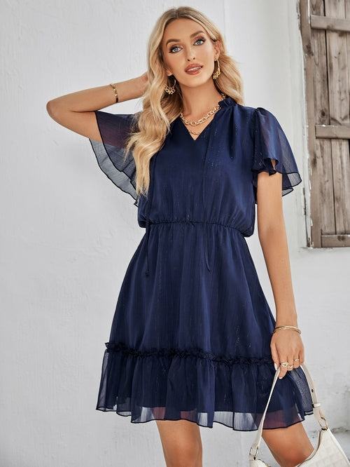 Women’s v-neck ruffle hem mini dress in a solid color featuring a flowy silhouette and adjustable waist tie