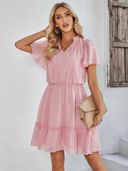 Women’s v-neck ruffle hem mini dress in a solid color featuring a flowy silhouette and adjustable waist tie