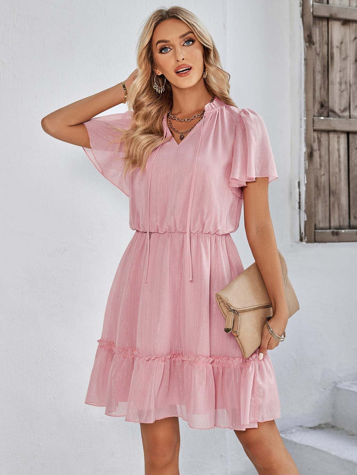 Women’s v-neck ruffle hem mini dress in a solid color featuring a flowy silhouette and adjustable waist tie